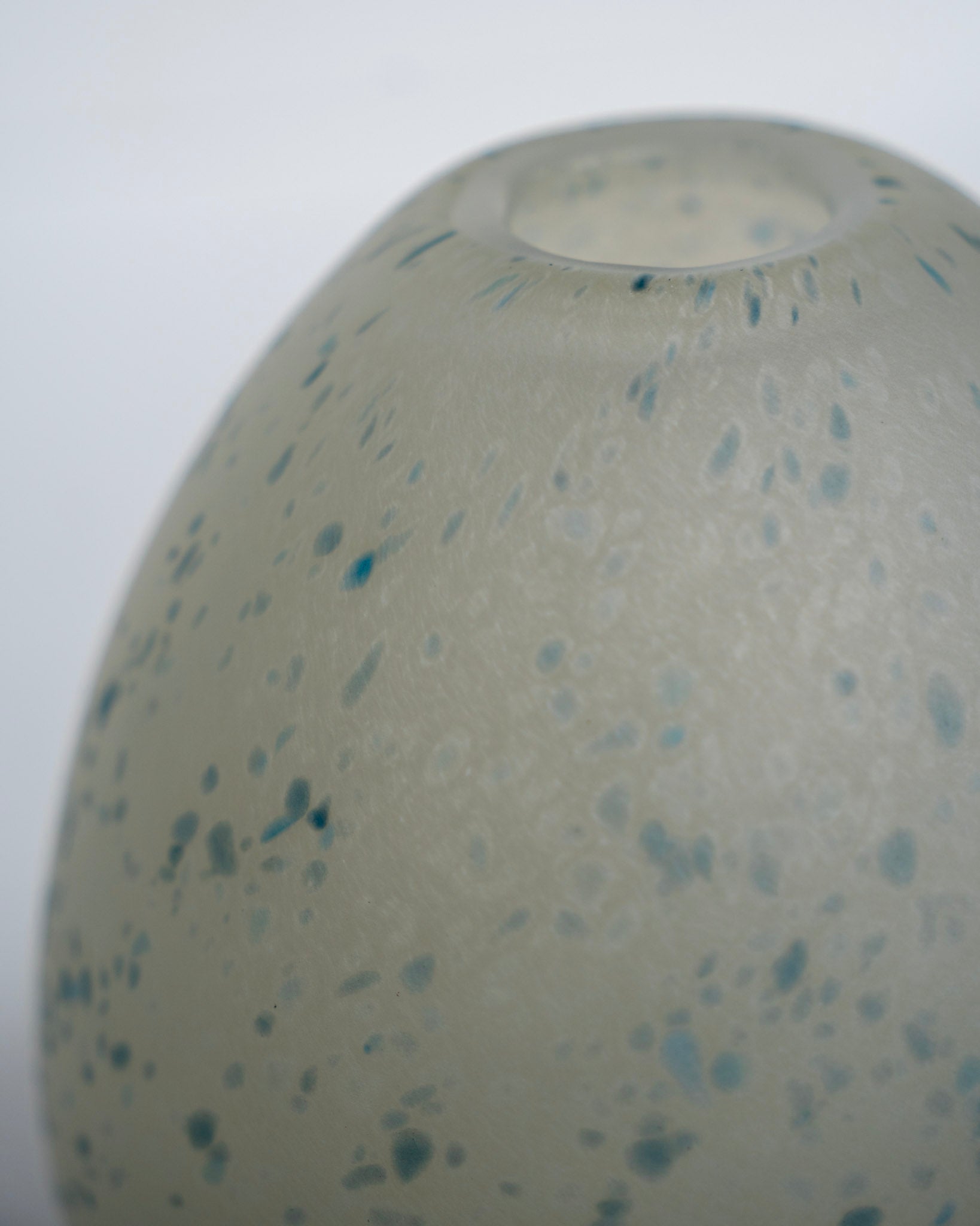 Eggevase i lys grønn med blå prikker, åpen topp og glatt rund overflate