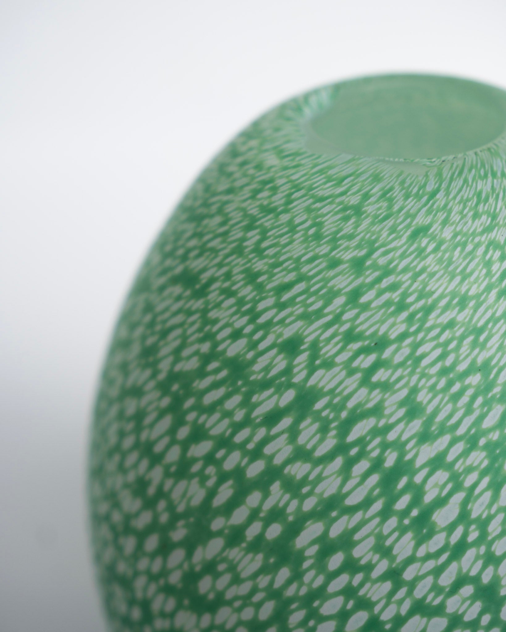 Grønn eggvase med hvite prikker og strukturert overflate