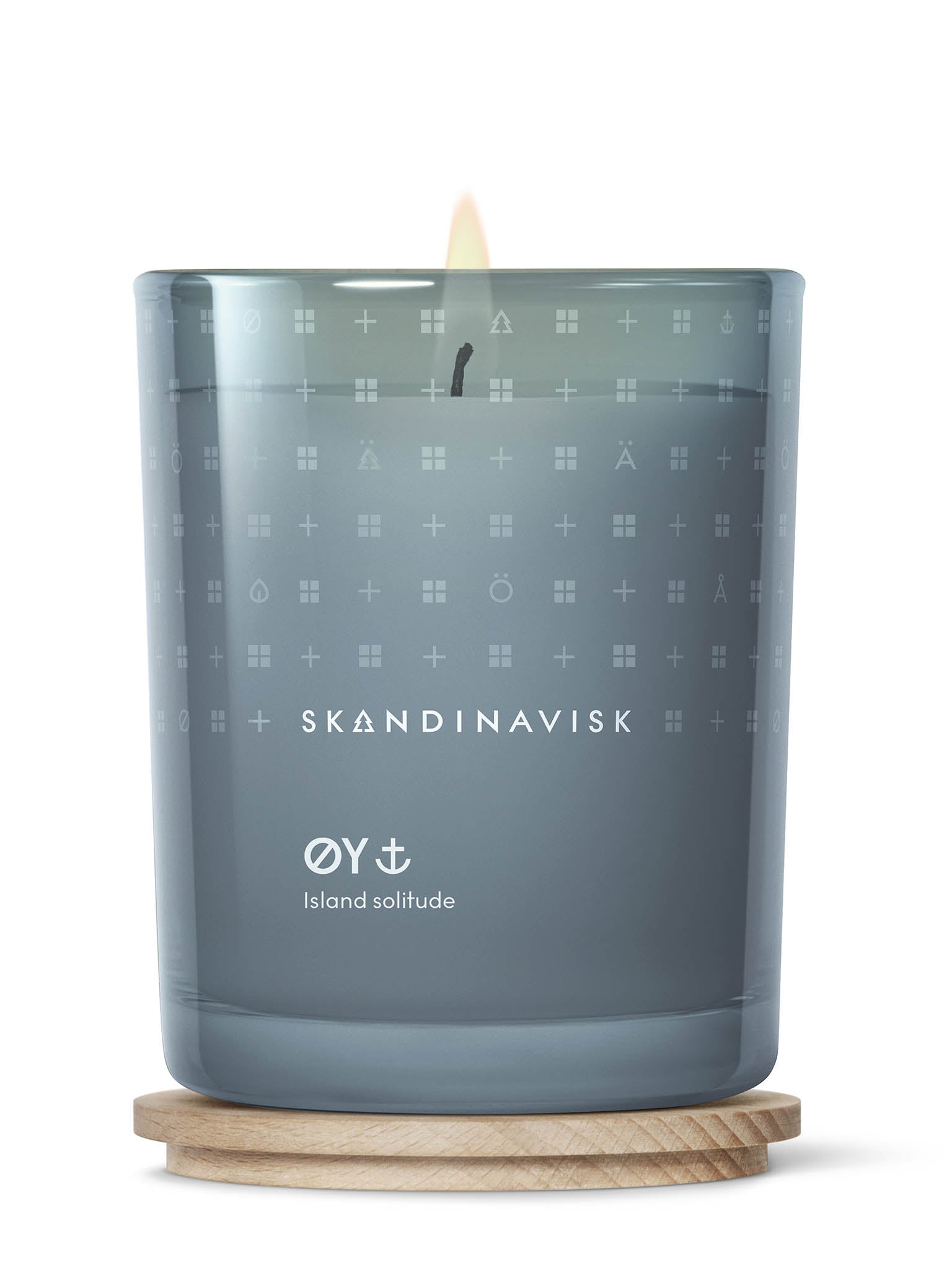 Duftlys i blå glasskrukke med brennende veke og treunderlag