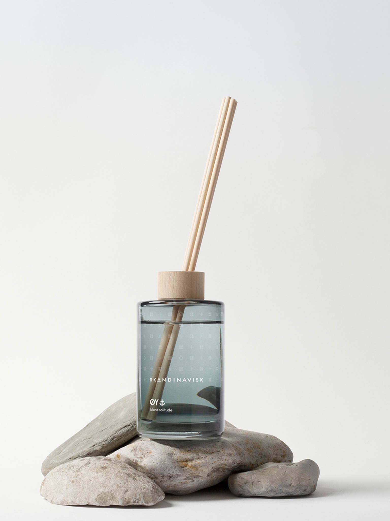Duftdiffuser 200 ml: glassflaske med tre sivrør på steinformet underlag.