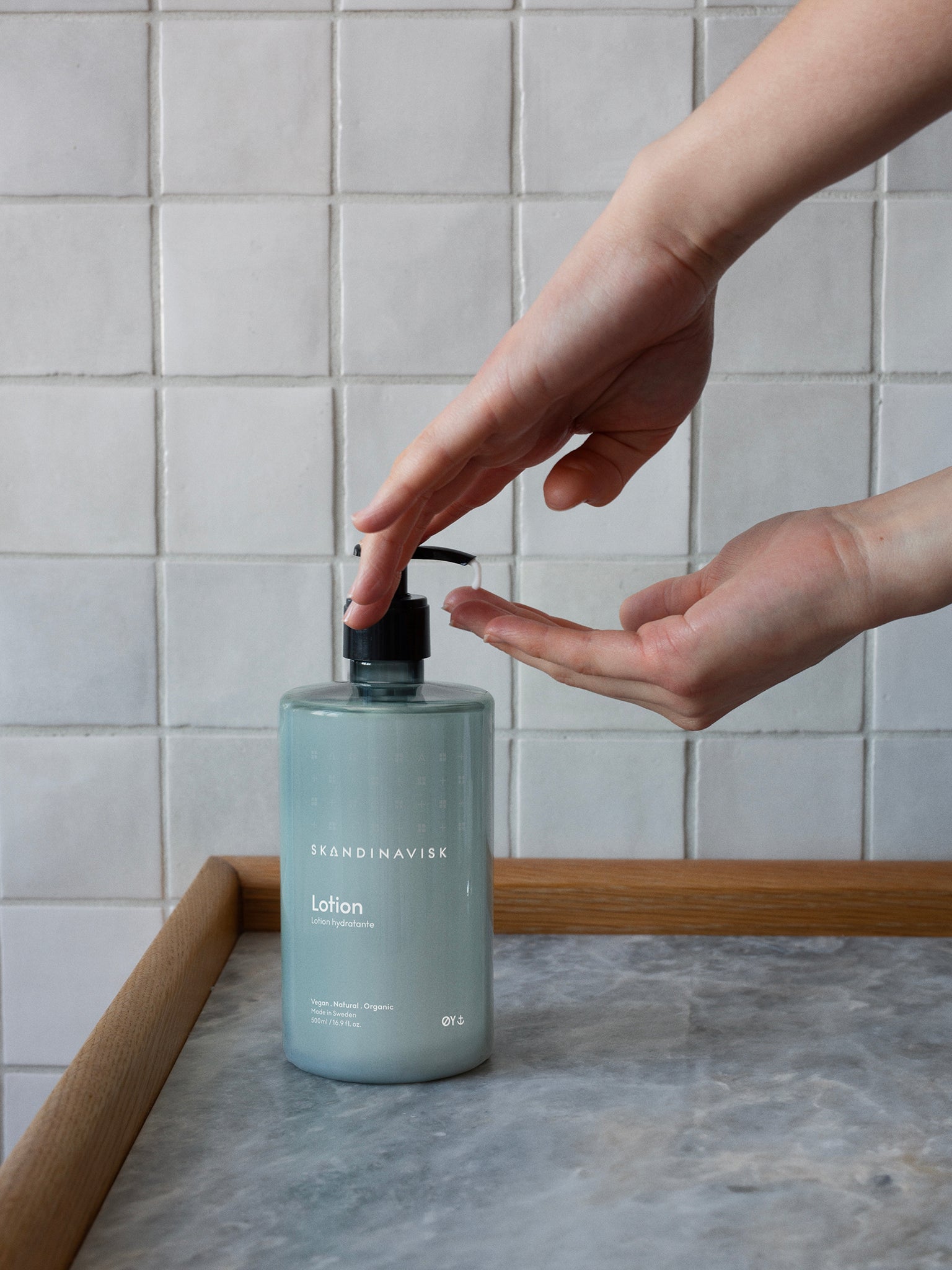ØY-lotionflaske med pumpe, hendene doserer lotion fra flasken
