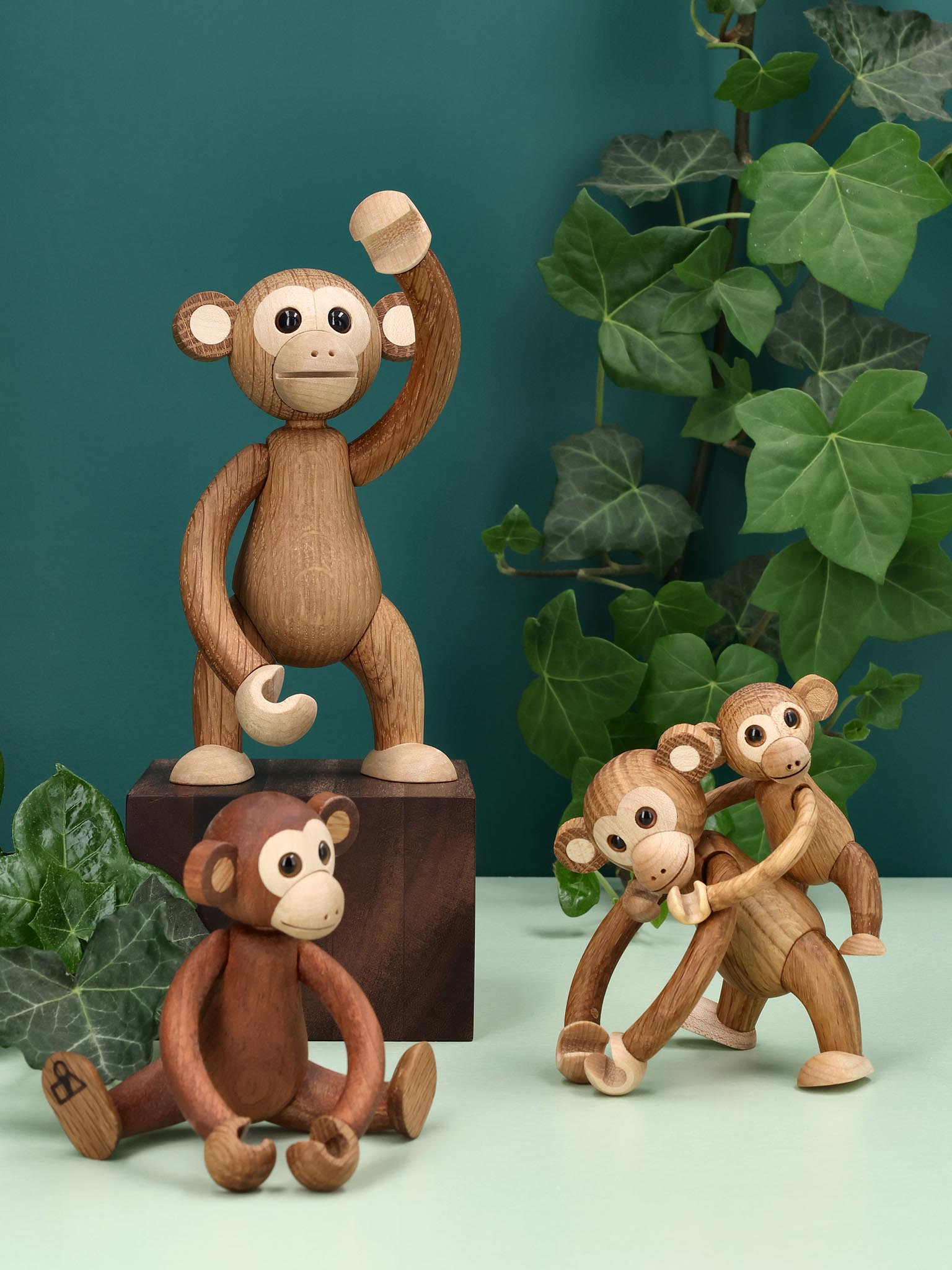 Flere apefigurer i tre-look på kubber, stor ape og små bak