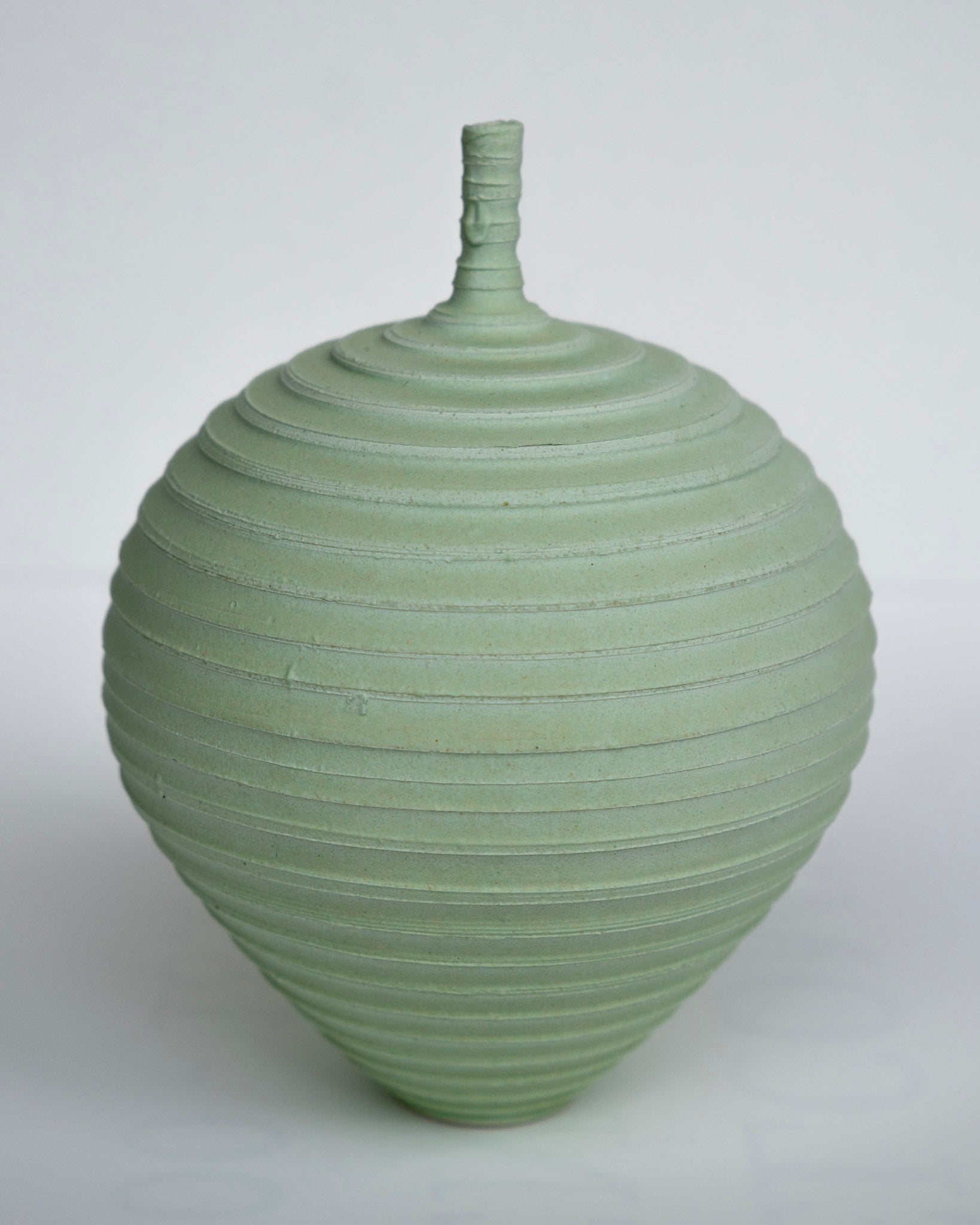 Mintgrønn vase med rillemønster og smal hals, rund form