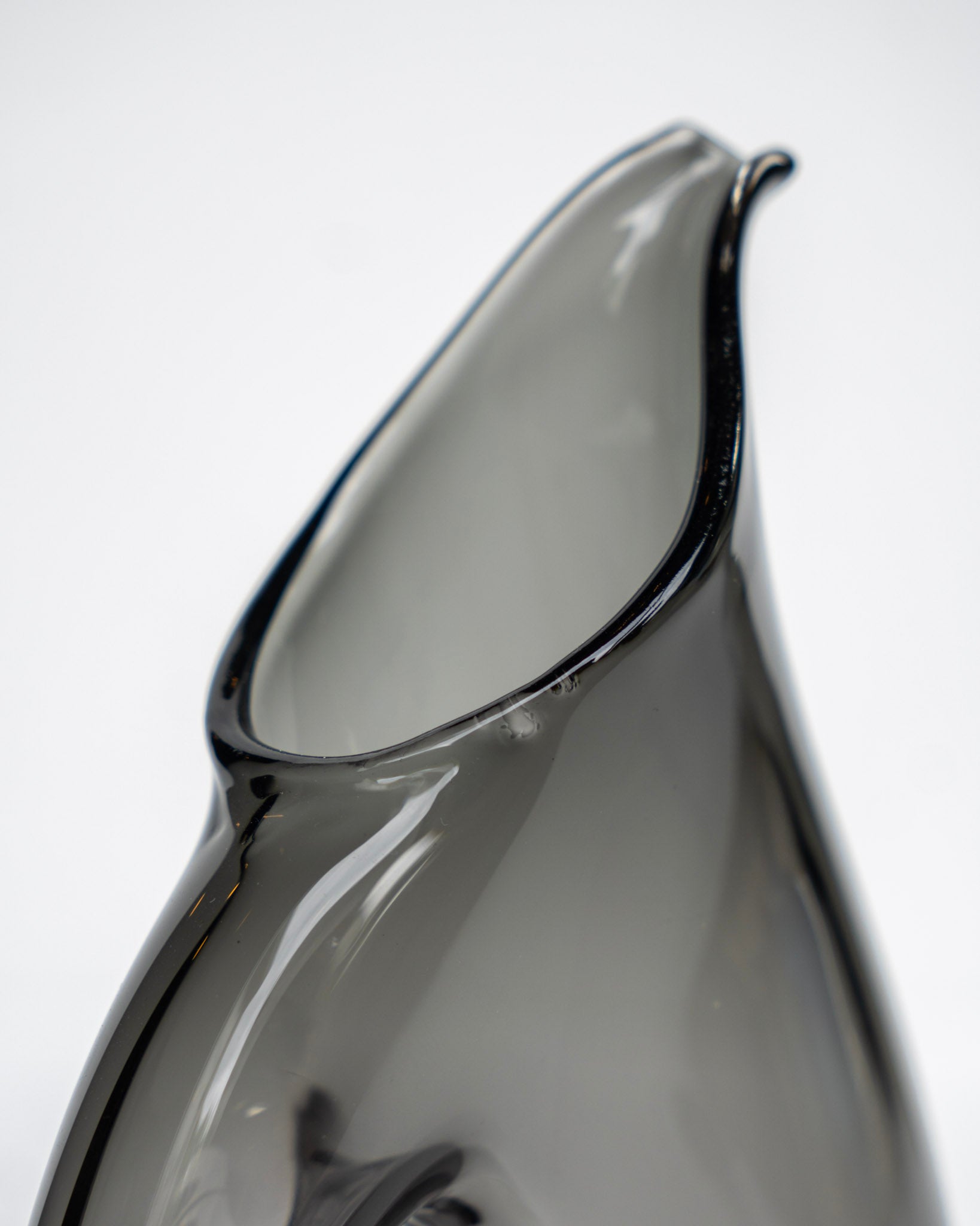 Svart fløtemugge nærbilde med blank glassoverflate og tuteform