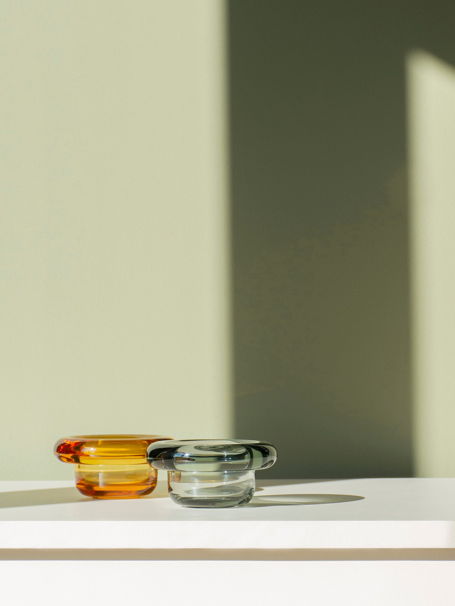Amber gul glassskål og klar glassskål på hylle