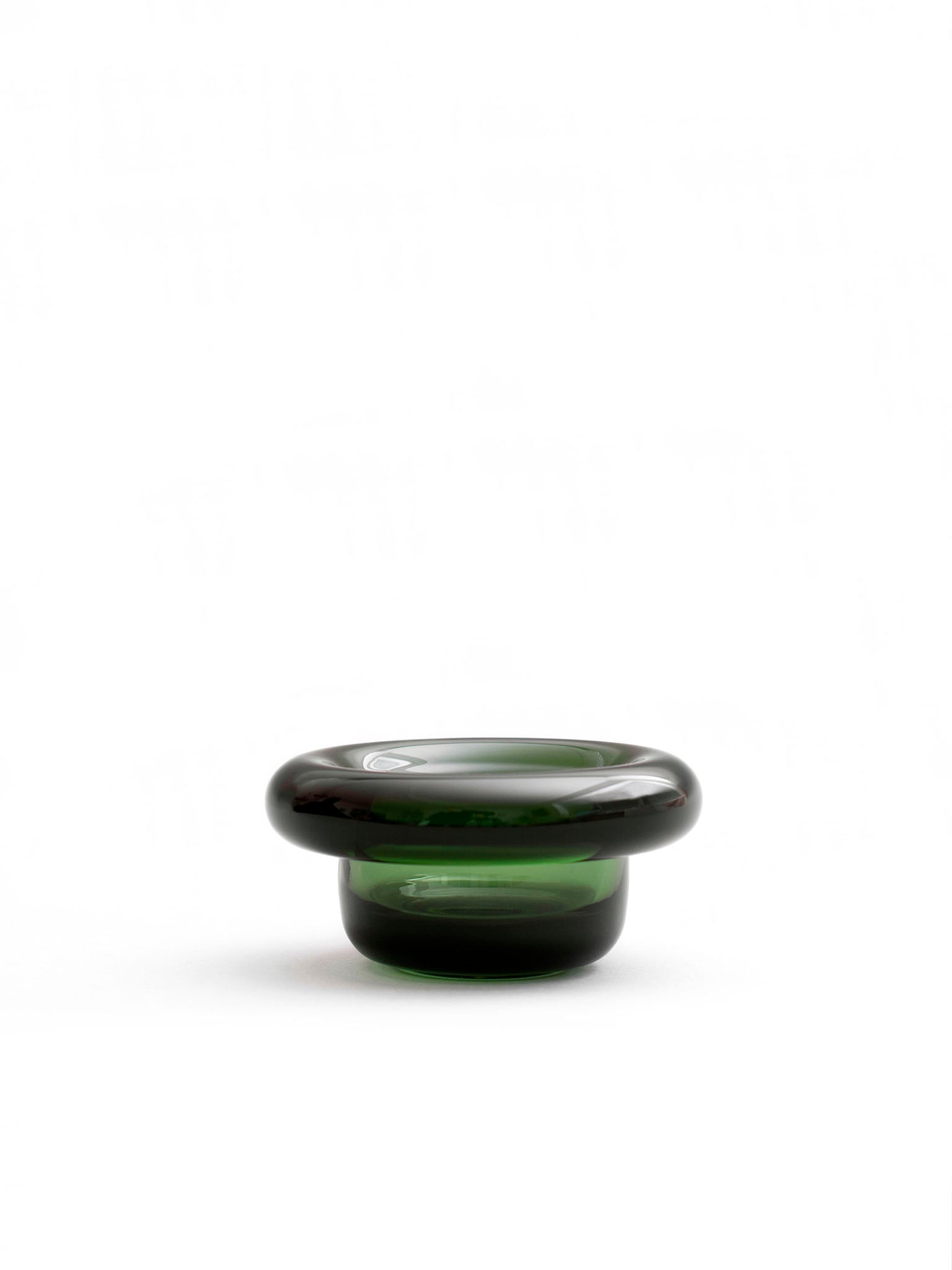 Mørk grønn sirkel-lysholder i glass med rund, lav skålform.