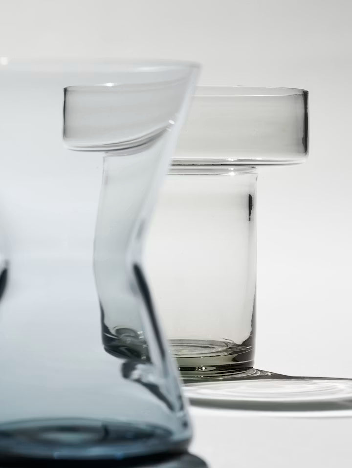 Nærbilde av minivase i klart blått glass med avrundet åpning og buet kropp