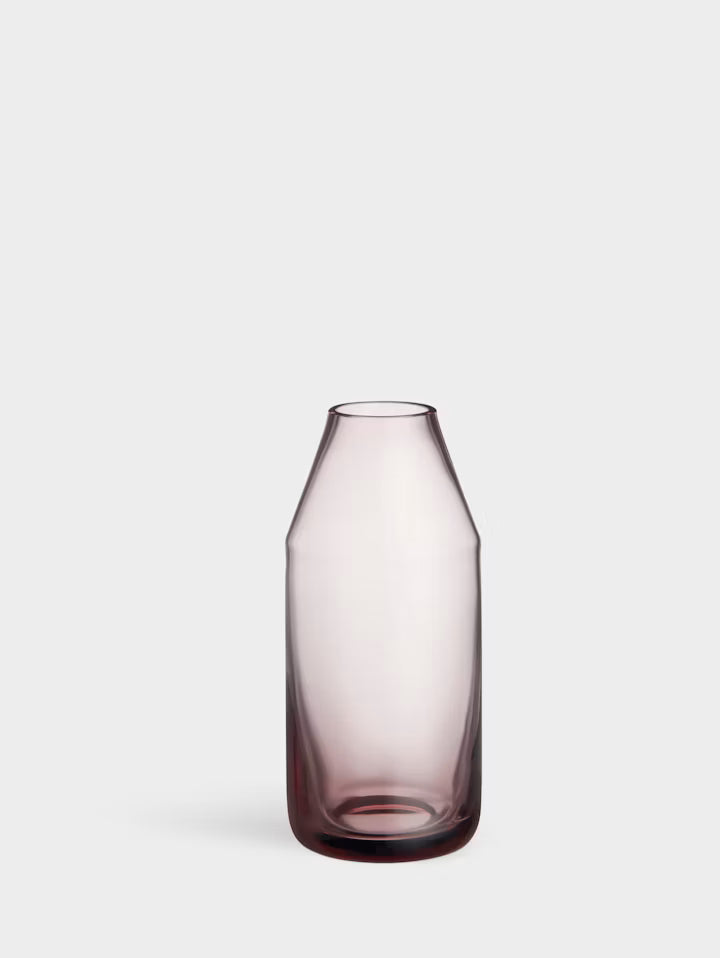 Minivase i klar glas med svag rosa tone og rund, mørkere bund