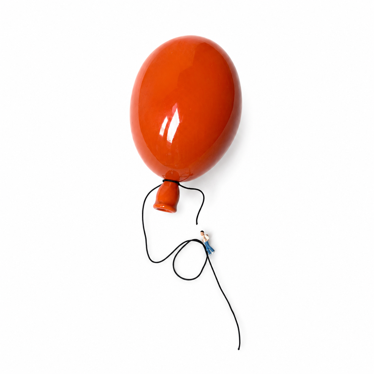 Oransje ballong med knute og lang snor