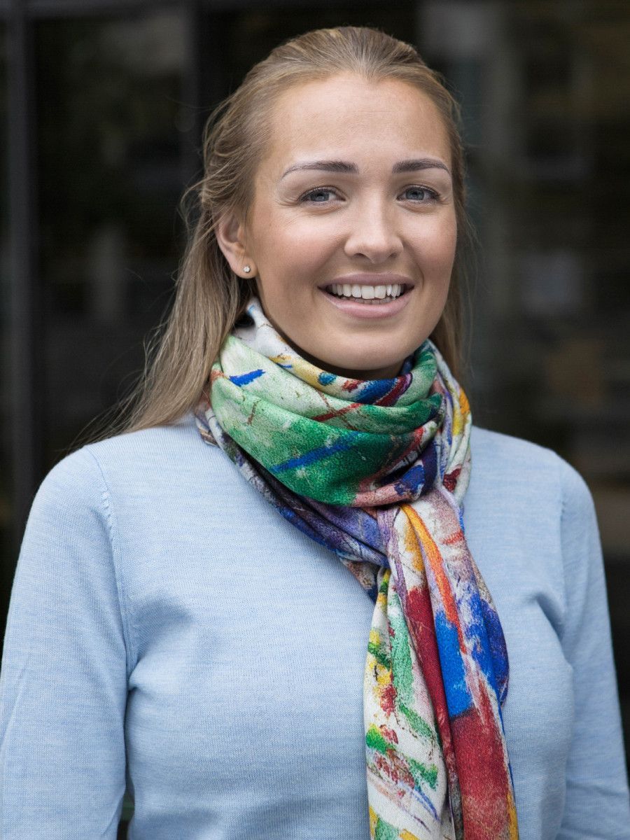 Multifarvet halstørklæde med farverigt mønster, båret om halsen