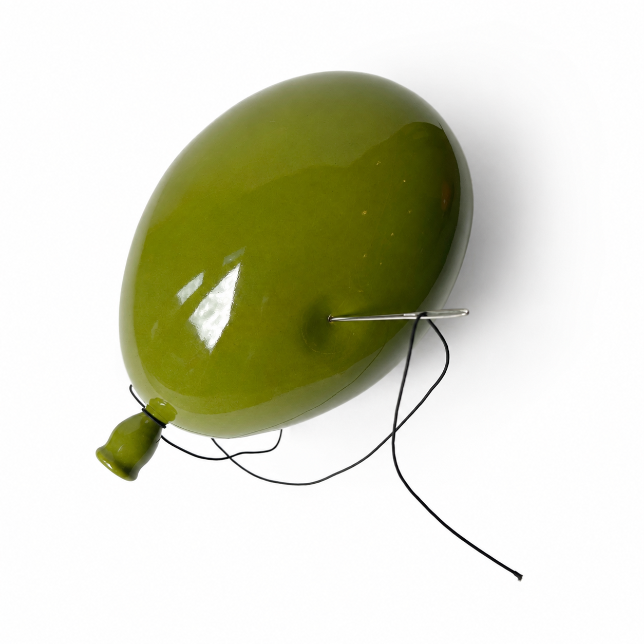Olivengrønn ballong med snor og metallstift ved knuten