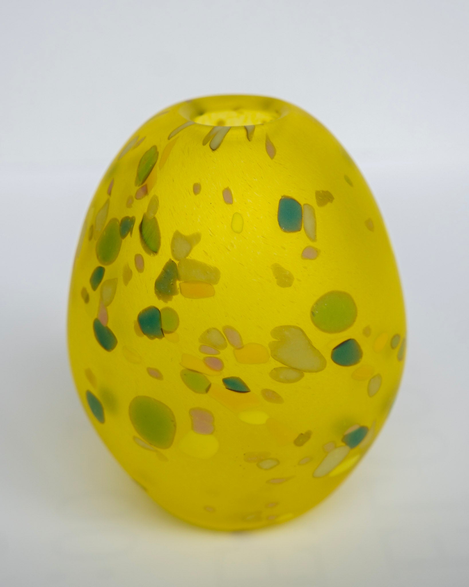 Eggevase gul med grønne og grå flekker, eggformet med åpen topp.