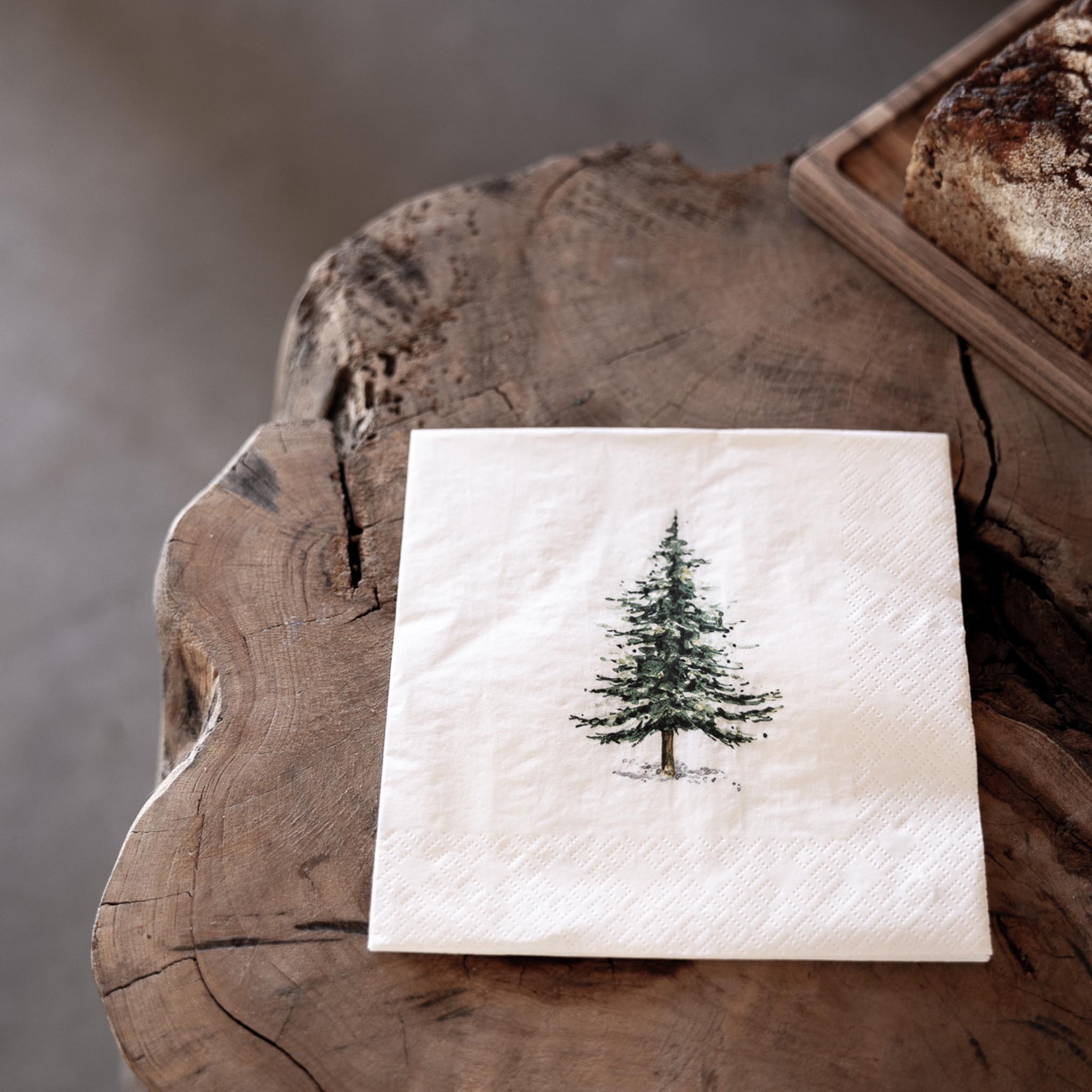 Serviett med juletreprint, lagt på treflate