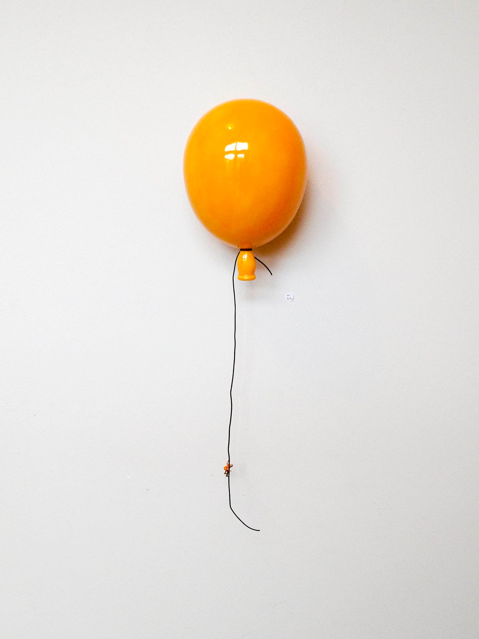 Oransje ballong med lang snor og liten knute