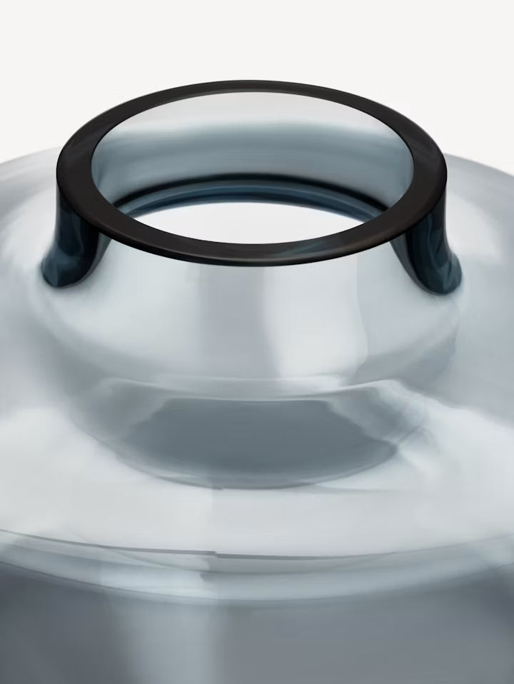 Nærbilde av mørk blågrå glassvase med tykk kant rundt åpningen