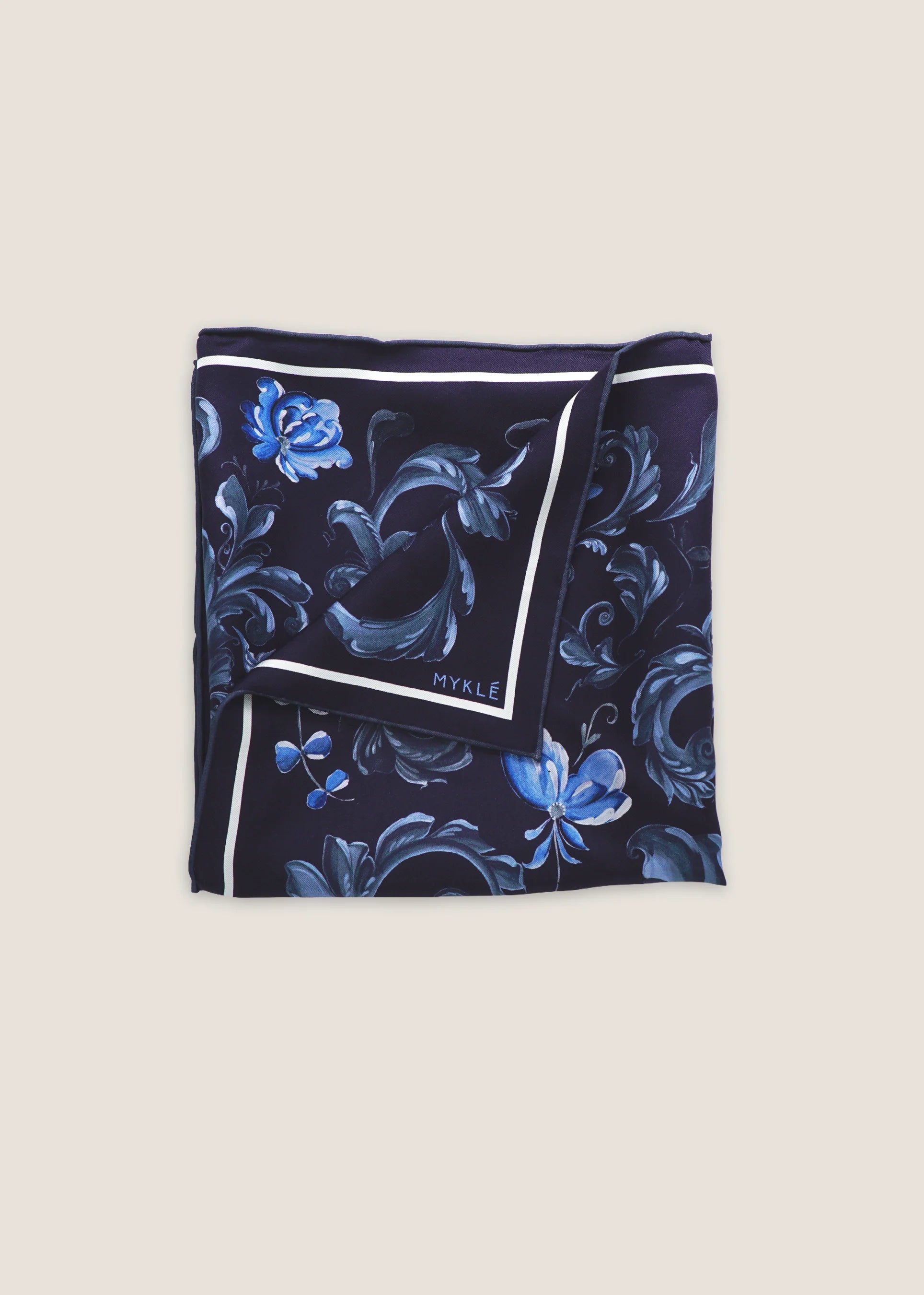 Silkeskjerf brettet firkantet i mørkeblått med blå blomster og striper