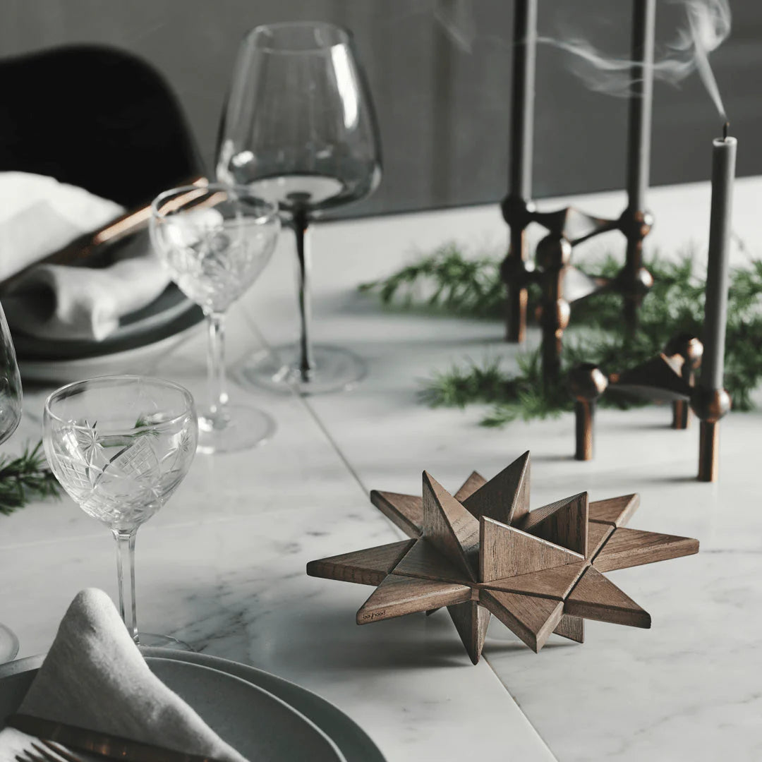 Stjerneformet bord i mørkt tre plassert ved spisebordet
